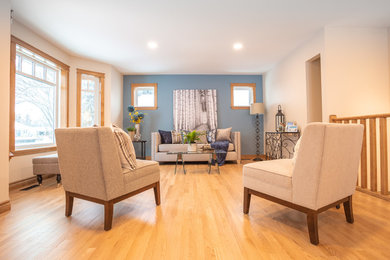 Diseño de salón abierto tradicional grande sin chimenea y televisor con paredes azules, suelo de madera en tonos medios y suelo marrón