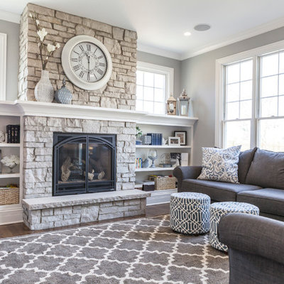 Example of a mid-sized transitional formal and enclosed dark wood floor and brown floor living room design in Chicago with gray walls, a standard fireplace, a stone fireplace and no tv