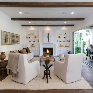 Foto de salón para visitas mediterráneo con paredes blancas, suelo de madera oscura, chimenea tradicional y suelo marrón