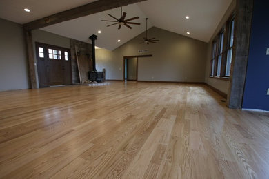 Elegant light wood floor and beige floor living room photo in Detroit with a wood stove
