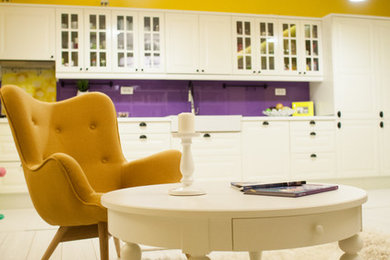 Imagen de salón abierto bohemio grande sin chimenea con paredes amarillas, suelo de madera clara, televisor colgado en la pared y suelo blanco
