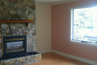 Example of a cottage chic light wood floor and beige floor living room design in Edmonton with pink walls, a standard fireplace and a stone fireplace