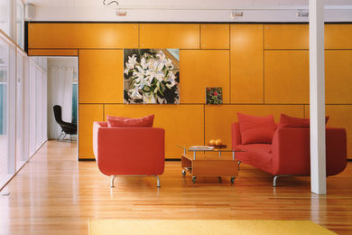 Imagen de salón cerrado actual de tamaño medio con paredes amarillas, suelo de madera clara y suelo beige