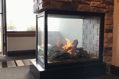 シカゴにあるトランジショナルスタイルのおしゃれなリビング (両方向型暖炉、金属の暖炉まわり) の写真