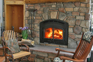デンバーにある中くらいなラスティックスタイルのおしゃれなリビング (マルチカラーの壁、カーペット敷き、標準型暖炉、石材の暖炉まわり、テレビなし) の写真