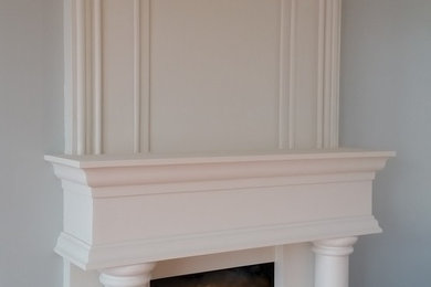 Imagen de salón clásico con paredes blancas, suelo de madera en tonos medios, todas las chimeneas y marco de chimenea de yeso