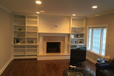 Example of a mid-sized arts and crafts formal and enclosed medium tone wood floor living room design in New York with white walls, a standard fireplace, a stone fireplace and a media wall