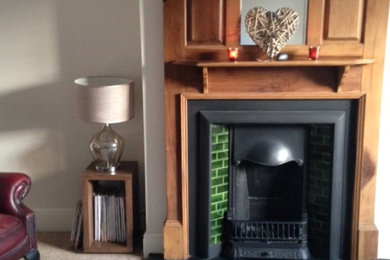 デヴォンにある低価格の中くらいなトラディショナルスタイルのおしゃれなLDK (ライブラリー、ベージュの壁、カーペット敷き、標準型暖炉、木材の暖炉まわり、据え置き型テレビ) の写真