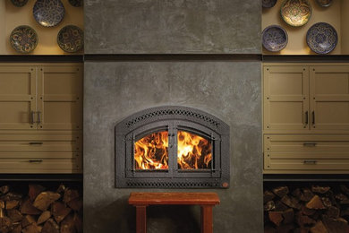 ポートランド(メイン)にある中くらいなトランジショナルスタイルのおしゃれなリビング (茶色い壁、セラミックタイルの床、標準型暖炉、コンクリートの暖炉まわり、テレビなし、茶色い床) の写真