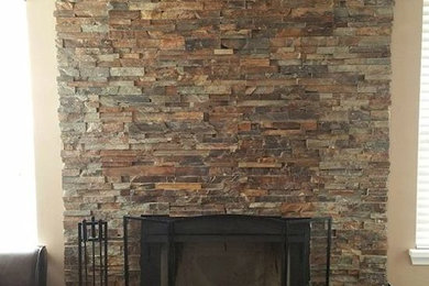Example of a living room design in Indianapolis with a wood stove