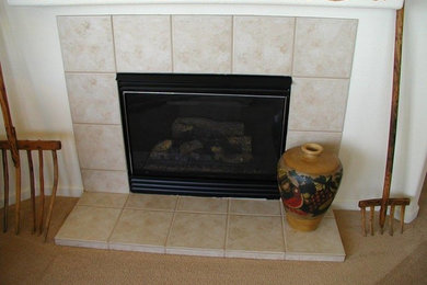他の地域にある低価格の中くらいなトラディショナルスタイルのおしゃれな独立型リビング (白い壁、カーペット敷き、標準型暖炉、タイルの暖炉まわり、ベージュの床) の写真