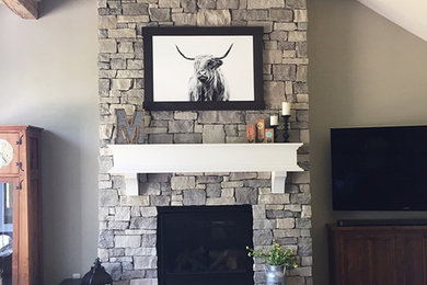 Example of a living room design in Other with a stone fireplace
