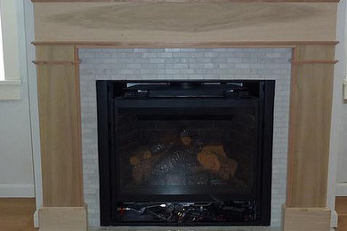 シアトルにある中くらいなおしゃれな独立型リビング (標準型暖炉、木材の暖炉まわり) の写真