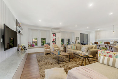 Idee per un grande soggiorno contemporaneo aperto con pareti multicolore, pavimento in legno massello medio e TV a parete