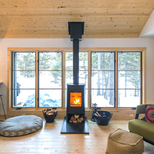 Small danish open concept light wood floor and beige floor living room photo in Other with white walls, a wood stove, a metal fireplace and a wall-mounted tv