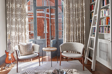 Esempio di un soggiorno chic chiuso con libreria, pareti grigie, pavimento in legno massello medio e pavimento marrone