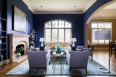 Example of a large transitional formal and enclosed medium tone wood floor and beige floor living room design with blue walls, a standard fireplace, a stone fireplace and no tv