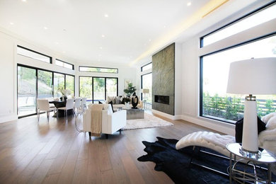 Example of a huge minimalist formal and open concept light wood floor and brown floor living room design in Los Angeles with white walls, a ribbon fireplace, a stone fireplace and no tv