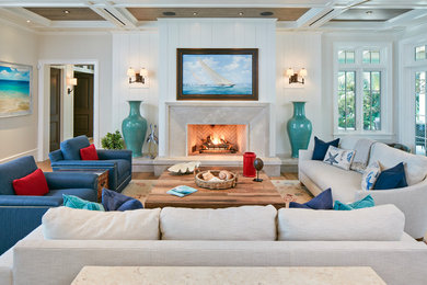 Photo of a large nautical enclosed living room in Denver with white walls, light hardwood flooring, a standard fireplace, brown floors, a concrete fireplace surround and no tv.