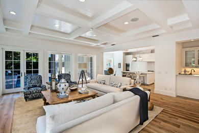 This is an example of an expansive contemporary open plan living room in Miami with white walls, no fireplace, a wall mounted tv, medium hardwood flooring and brown floors.