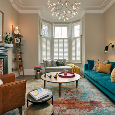 Living room - mid-sized contemporary enclosed medium tone wood floor and brown floor living room idea in London with beige walls, a standard fireplace, a metal fireplace and no tv