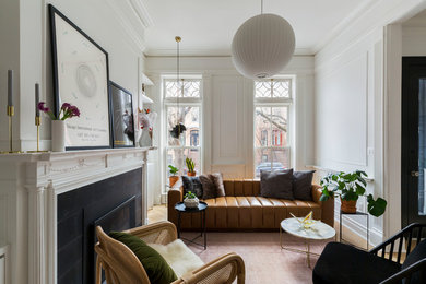 This is an example of a small traditional formal enclosed living room in New York with white walls, light hardwood flooring, a standard fireplace, a tiled fireplace surround, no tv and beige floors.