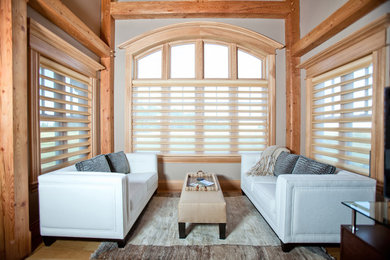 Ejemplo de salón abierto de estilo americano grande con paredes grises y suelo de madera clara