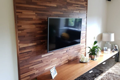 Modelo de salón cerrado actual de tamaño medio con paredes blancas, televisor colgado en la pared y madera