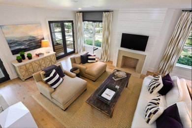 Example of a mid-sized transitional formal and enclosed light wood floor living room design in Jacksonville with white walls, a standard fireplace, a plaster fireplace and a wall-mounted tv