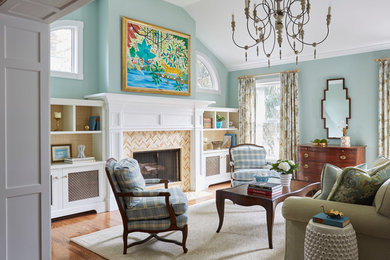 Diseño de salón abierto clásico de tamaño medio con paredes azules, suelo de madera en tonos medios, todas las chimeneas, marco de chimenea de baldosas y/o azulejos y suelo beige