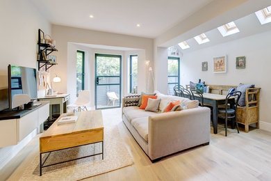 Cette image montre un salon minimaliste de taille moyenne et ouvert avec un mur gris, un sol en bois brun et un téléviseur indépendant.