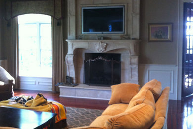 Example of a classic enclosed medium tone wood floor living room design in Chicago with a standard fireplace, a stone fireplace and a wall-mounted tv