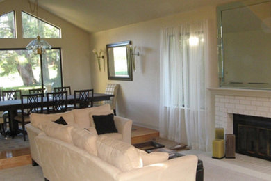 Wohnzimmer mit beiger Wandfarbe, hellem Holzboden, Kamin und Kaminumrandung aus Backstein in San Francisco