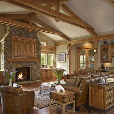 Example of a huge mountain style living room design in Denver with a standard fireplace, a stone fireplace, a concealed tv and a bar