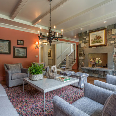 Large elegant enclosed medium tone wood floor living room photo in Milwaukee with a stone fireplace, orange walls, a standard fireplace and a wall-mounted tv