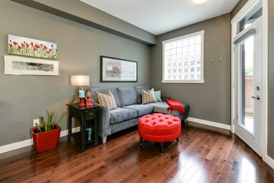 Cette photo montre un petit salon tendance ouvert avec un mur gris, un sol en bois brun et un téléviseur indépendant.