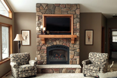 Inspiration for a carpeted living room remodel in Minneapolis with beige walls, a standard fireplace, a stone fireplace and a wall-mounted tv