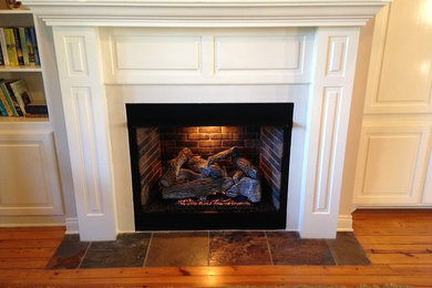 Example of a mid-sized classic formal and enclosed dark wood floor and brown floor living room design in New Orleans with white walls, a standard fireplace, a plaster fireplace and no tv
