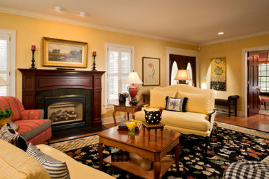 Ejemplo de salón cerrado campestre grande con paredes amarillas, suelo de madera en tonos medios, todas las chimeneas y marco de chimenea de madera