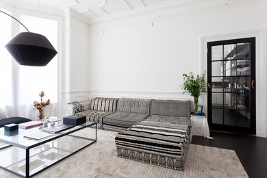 Immagine di un grande soggiorno minimalista aperto con sala formale, pareti bianche, pavimento in cemento, camino classico, cornice del camino in cemento e TV nascosta