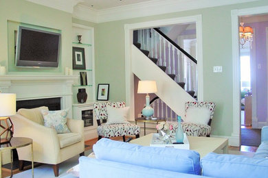 ワシントンD.C.にある低価格の中くらいなトランジショナルスタイルのおしゃれなリビング (緑の壁、無垢フローリング、標準型暖炉、壁掛け型テレビ、ベージュの床) の写真