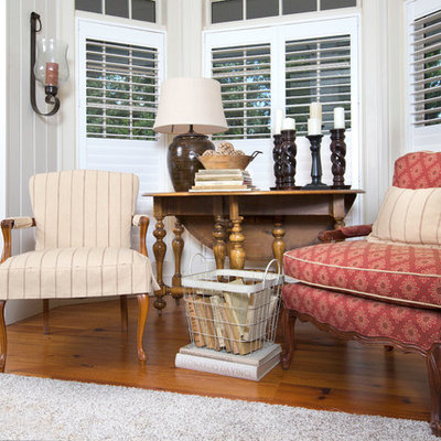 Example of a large country medium tone wood floor living room design in Atlanta with white walls and no fireplace