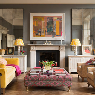 Transitional medium tone wood floor and brown floor living room photo in Edinburgh with gray walls and a standard fireplace