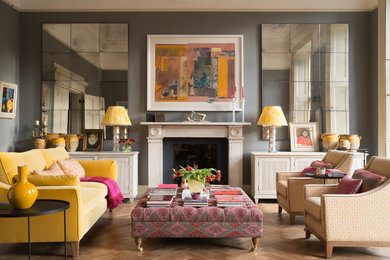 Ispirazione per un soggiorno chic con pareti grigie, pavimento in legno massello medio, camino classico e pavimento marrone