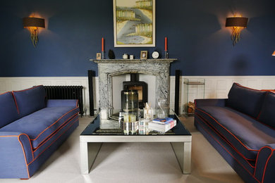 This is an example of a large classic formal enclosed living room in West Midlands with blue walls, carpet, a wood burning stove, a stone fireplace surround, a wall mounted tv and grey floors.