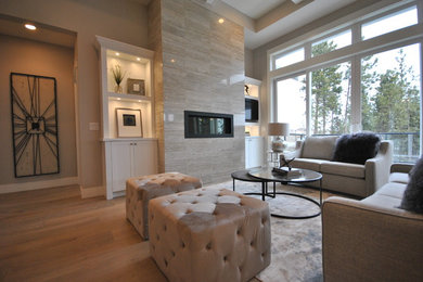 Großes, Offenes Klassisches Wohnzimmer mit grauer Wandfarbe, hellem Holzboden, Gaskamin, gefliester Kaminumrandung, Multimediawand und beigem Boden in Vancouver