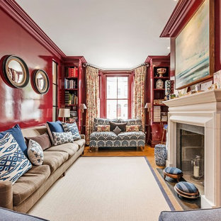 Medium sized classic living room with red walls, medium hardwood flooring, a standard fireplace and a reading nook.