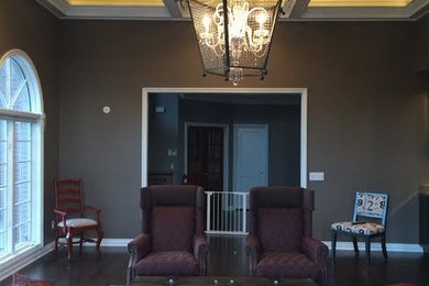 Foto de salón cerrado grande con paredes beige, suelo de madera oscura, chimenea de doble cara, marco de chimenea de madera y televisor colgado en la pared