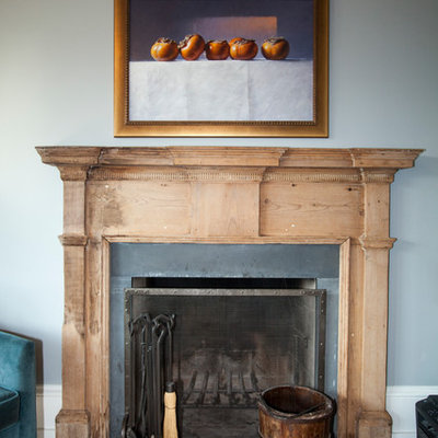 Large country enclosed medium tone wood floor living room photo in Philadelphia with gray walls, a standard fireplace, a wood fireplace surround and a wall-mounted tv