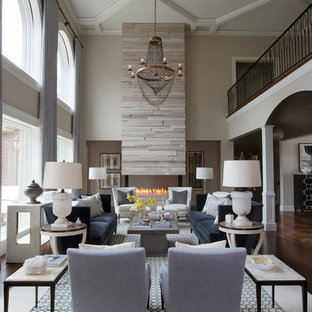 Inspiration for a large transitional formal and open concept medium tone wood floor living room remodel in Other with gray walls, a two-sided fireplace, a stone fireplace and no tv